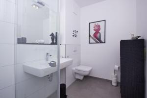 ein weißes Badezimmer mit Waschbecken und Toilette in der Unterkunft zentrale FeWo mit Balkon, gratis Nutzung vom AHOI Erlebnisbad und Sauna in Sellin - Villa Anni FeWo 05 in Göhren