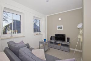 a living room with a couch and a tv at Ferienwohnung Liesi FeWo OG - Balkon, ruhige Lage in Putbus