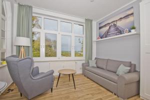 ein Wohnzimmer mit einem Sofa und einem Tisch in der Unterkunft Haus Brandenburg FeWo 37 - strandnah in Göhren