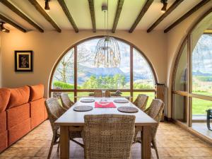 a dining room with a table and chairs and a large window at Holiday Home Villa Elorrio by Interhome in Elorrio