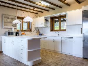 Holiday Home Villa Elorrio by Interhome في Elorrio: مطبخ أبيض مع خزائن بيضاء وأجهزة