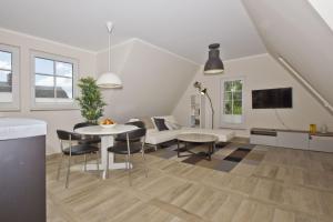 a living room with a table and a couch at Ferienhaus Auszeit FeWo 03 - Dachterrasse, ruhige Lage in Middelhagen
