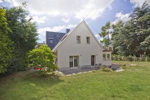 una casa blanca en un patio con un campo verde en Ferienhaus Auszeit FeWo 03 - Dachterrasse, ruhige Lage, en Middelhagen