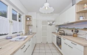 una cucina con armadi bianchi e una grande finestra di Ferienhaus Gisela Gartenblick - Terrasse, Garten, Sauna a Putbus