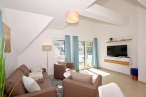 ein Wohnzimmer mit Sofa und Fernseher in der Unterkunft strandnahe FeWo mit Balkon, gratis Nutzung vom AHOI Erlebnisbad und Sauna in Sellin - Rex Rugia FeWo 10-7 in Lobbe