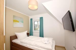 ein kleines Schlafzimmer mit einem Bett und einem Fenster in der Unterkunft strandnahe FeWo mit Balkon, gratis Nutzung vom AHOI Erlebnisbad und Sauna in Sellin - Rex Rugia FeWo 10-7 in Lobbe + 14 Fotos