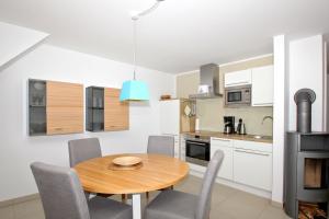 eine Küche und ein Esszimmer mit einem Holztisch und Stühlen in der Unterkunft strandnahe FeWo mit Balkon, gratis Nutzung vom AHOI Erlebnisbad und Sauna in Sellin - Rex Rugia FeWo 30-6 in Lobbe