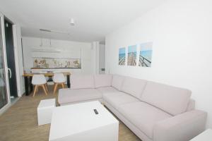 - un salon blanc avec un canapé blanc et une table dans l'établissement Haus Hafenkieker FeWo 08 - Balkon, Hafenblick, à Putbus