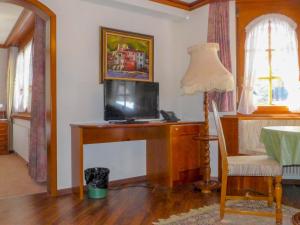 Zimmer mit einem Schreibtisch, einem TV und einer Lampe in der Unterkunft Apartment by Interhome in Zermatt