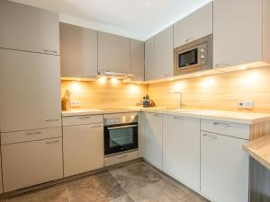 a kitchen with white cabinets and a microwave at Apartment Aileen by Interhome in Fliess