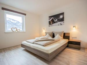 a bedroom with a large bed with a window at Apartment Aileen by Interhome in Fliess