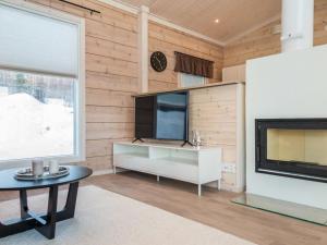 a living room with a tv and a fireplace at Holiday Home Viherlaakso a by Interhome in Tahkovuori