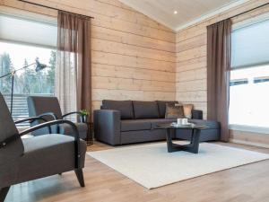 a living room with a couch and a table at Holiday Home Viherlaakso a by Interhome in Tahkovuori