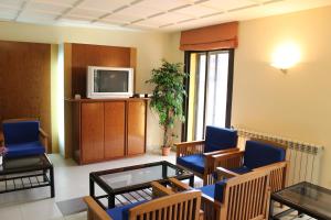 a waiting room with blue chairs and a tv at Hotel Sabiote in Pineda de Mar