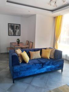 a blue couch with pillows in a living room at Nalabba in Dakar