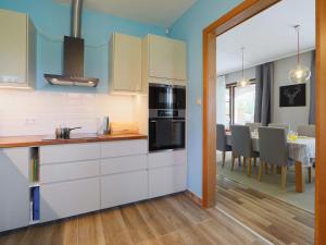 a kitchen with white cabinets and a dining room at Villa Aschbacher by Interhome in Balatonszemes +35 photos