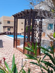 エル・アラメインにあるAL saha2 Basement Chalets villa114 Green Beachのスイミングプール横の木製パーゴラ