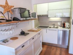 cocina con fregadero y microondas en Studio Bouleaux B1 by Interhome, en Nendaz