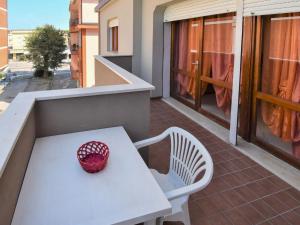 un cuenco rojo sentado en una mesa blanca en un balcón en Apartment Rosapanna-1 by Interhome, en Rosapineta