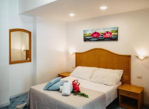 - une chambre avec un lit fleuri dans l'établissement Hotel Rojas, à Vulcano