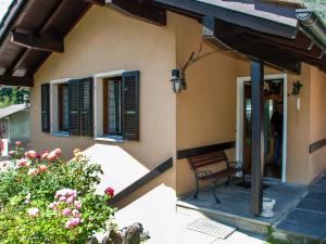 two pictures of a house with a bench and flowers at Holiday Home La Casina by Interhome in Olivone