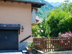 a house with a black door and a fence at Holiday Home La Casina by Interhome in Olivone