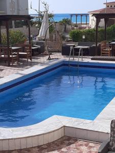 ein Schwimmbad mit blauem Wasser in einem Ferienort in der Unterkunft saha3 Basement villa 114 green beach in El-Alamein