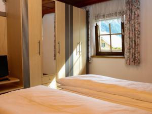 1 Schlafzimmer mit 2 Betten und einem Fenster in der Unterkunft Holiday Home Gebhardt by Interhome in Zederhaus