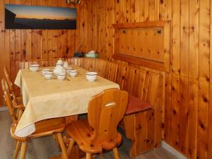 a dining room with a table with bowls and cups on it at Apartment Platanes A1 by Interhome in Nendaz