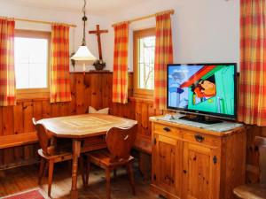 een eetkamer met een tv en een houten tafel bij Holiday Home Wierer-2 by Interhome in Fügen