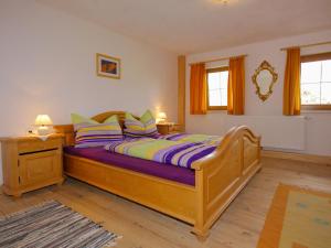 een slaapkamer met een groot houten bed met paarse lakens bij Holiday Home Wierer-2 by Interhome in Fügen