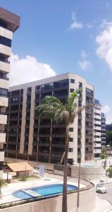 マセイオにあるExcelente Apartamento Maceióのプール前のヤシの木がある建物