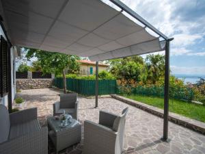 un patio con sombrilla blanca y sillas en Holiday Home Erminia by Interhome, en Lovran