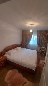 a bedroom with a large bed and a window at CASA DINCA in Cîmpu lui Neag