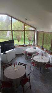 a room with two tables and chairs and windows at CASA DINCA in Cîmpu lui Neag