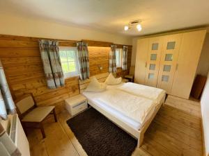 ein Schlafzimmer mit einem Bett, einem Stuhl und einem Fenster in der Unterkunft Arlerhof in Untertauern