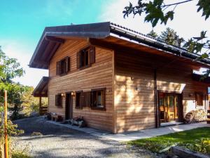 a log cabin with a porch in a yard at Chalet Banksia by Interhome in Ovronnaz