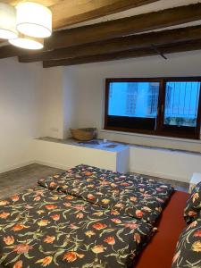 a bedroom with a bed and a large window at Schöne Ferienwohnung Gewölbekeller Fachwerkhaus in Bacharach