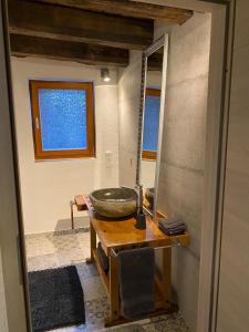 a bathroom with a bowl on a table and a mirror at Schöne Ferienwohnung Gewölbekeller Fachwerkhaus in Bacharach