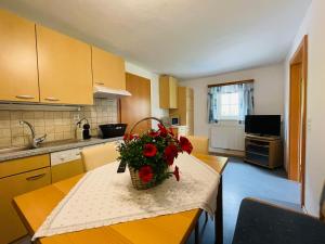 a kitchen with a table with a vase of flowers on it at Arlerhof in Untertauern