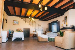 sala de estar con mesas y sillas y techo en Alojamiento rural Las Alberquillas, en Beas