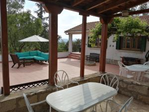 patio con tavolo, sedie e ombrellone di La Casa del Ingles - Robledillo de la Jara a Robledillo de la Jara