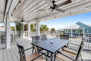 a table and chairs on a deck with a ceiling fan at Sunshine's Holiday in Panama City Beach