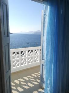 an open door with a view of the ocean at Massouri Rooms in Masouri