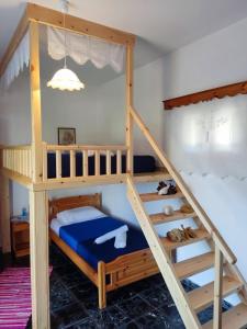 a bunk bed with a ladder and a bunk bed with at Petroula Apartments in Emborios Kalymnos