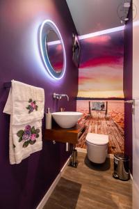 a bathroom with a toilet and a sink and a mirror at La Chambre Rose in Ponta do Sol +11 photos