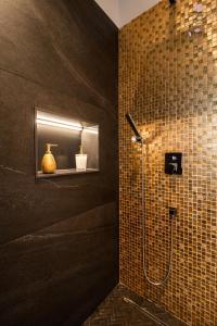 Łazienka z prysznicem wyłożona jest brązowymi kafelkami. w obiekcie La Chambre Rose w mieście Ponta do Sol