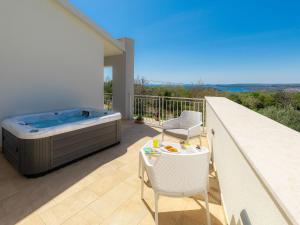 a balcony with a hot tub and a table and chairs at Villa Laura by Interhome in Koromačno