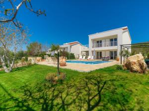 a house with a yard with a swimming pool at Villa Laura by Interhome in Koromačno