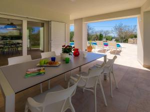 a dining room with a table and chairs at Villa Laura by Interhome in Koromačno
